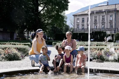 Zwei Frauen mit Kindern am Brunnen