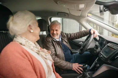 Rotkreuz-Fahrer und Fahrgast unterhalten sich im Auto