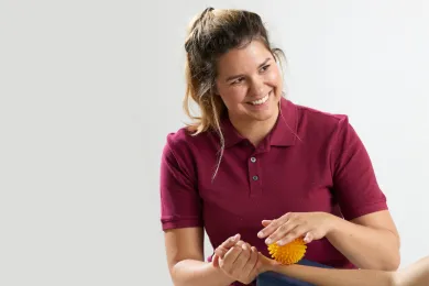 Ergotherapeutin bei einer Handtherapie und im Gespräch mit der Patientin