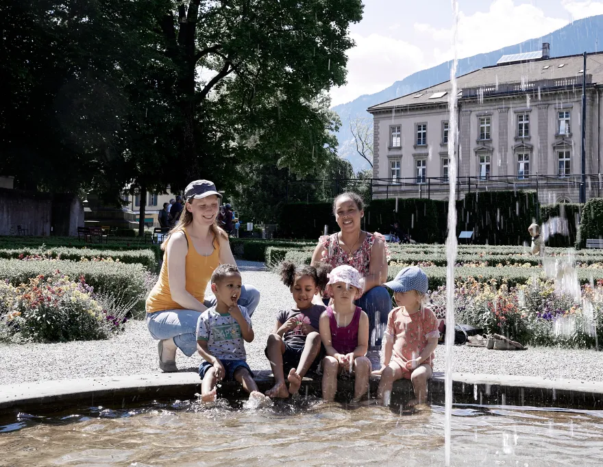 Zwei Frauen mit Kindern am Brunnen