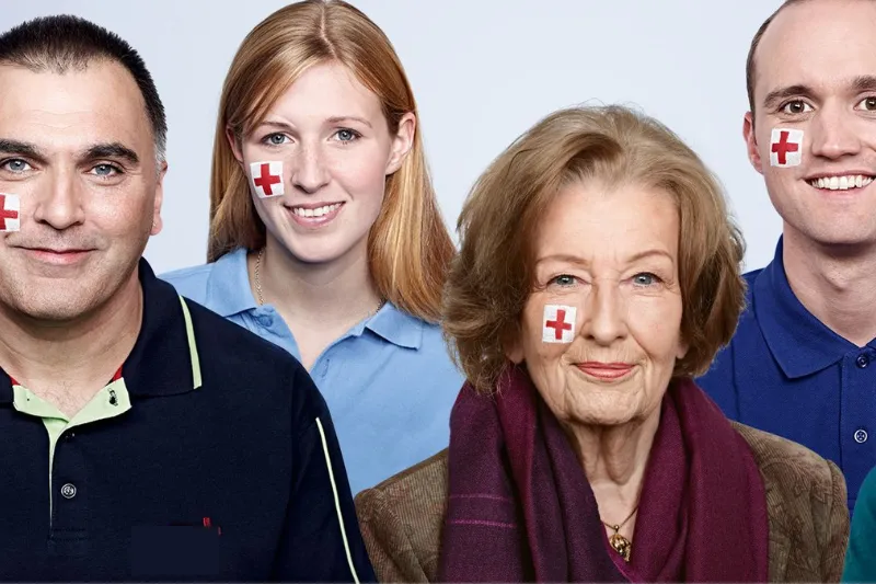 Gruppenfoto mit Menschen mit Rotkreuz-Flaggen auf Wange