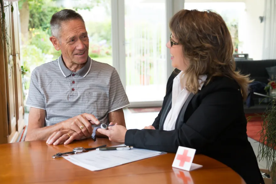 Freiwillige Mitarbeiterin im Gespräch mit älterem Mann